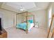 Spacious main bedroom featuring a tray ceiling, neutral walls, and a decorative four-poster bed with turquoise accents at 2420 Sapphire Valley Dr, Raleigh, NC 27604