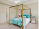 Bright main bedroom featuring a four-poster bed with turquoise accents, neutral walls, and a ceiling fan at 2420 Sapphire Valley Dr, Raleigh, NC 27604