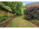 Backyard with well-maintained lawn, trees, and established garden beds at 2507 Mayview Rd, Raleigh, NC 27607