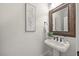Bathroom features a pedestal sink, decorative mirror, light fixture, and decorative wall art at 2507 Mayview Rd, Raleigh, NC 27607