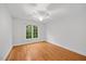 Bedroom featuring hardwood floors, a window with a treeline view, and neutral-colored walls at 2507 Mayview Rd, Raleigh, NC 27607