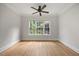 Bedroom with hardwood flooring, white walls, a ceiling fan, and a window with natural light at 2507 Mayview Rd, Raleigh, NC 27607