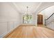 Bright dining room with hardwood floors, wainscoting, and a large window overlooking the landscaped yard at 2507 Mayview Rd, Raleigh, NC 27607
