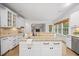 Bright kitchen island boasts granite countertops and stainless steel faucet; views of living room with fireplace at 2507 Mayview Rd, Raleigh, NC 27607
