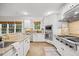 Modern kitchen with white cabinets, stainless steel appliances, granite countertops, and large windows for natural lighting at 2507 Mayview Rd, Raleigh, NC 27607