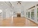 Open-concept living room with hardwood floors, a fireplace, built-in shelving, and large glass doors at 2507 Mayview Rd, Raleigh, NC 27607