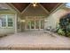 Inviting outdoor patio with stone flooring, french doors, seating, and ceiling fan at 2507 Mayview Rd, Raleigh, NC 27607