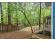 Landscaped backyard with mature trees and steps up to a screened porch, and fenced yard at 2525 Buxton Ct, Chapel Hill, NC 27514