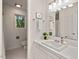 Bathroom with white cabinets, a large mirror, a window with nature views, and light tiling at 2525 Buxton Ct, Chapel Hill, NC 27514