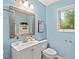 This light blue bathroom is quaint with a large mirror and a window view of the forest at 2525 Buxton Ct, Chapel Hill, NC 27514
