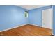 This empty bedroom has hardwood floors, one window, a closet, and blue walls at 2525 Buxton Ct, Chapel Hill, NC 27514