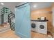 Functional laundry room featuring modern washer and dryer, and sliding barn door to staircase at 2525 Buxton Ct, Chapel Hill, NC 27514
