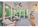 Bright sunroom featuring hardwood floors, a ceiling fan, an area rug, and two lounge chairs at 2525 Buxton Ct, Chapel Hill, NC 27514