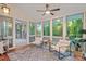 Bright sunroom featuring hardwood floors, a ceiling fan, an area rug, and two lounge chairs at 2525 Buxton Ct, Chapel Hill, NC 27514