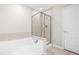 Bright bathroom featuring soaking tub, glass enclosed shower, and a tiled shower surround at 2622 Perthshire Ln, Fuquay Varina, NC 27526