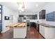 Modern kitchen with stainless steel appliances, a large island with butcher block top, and stylish dark cabinets at 2622 Perthshire Ln, Fuquay Varina, NC 27526