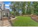 The backyard includes a stone path, dining area, covered deck and large grassy space surrounded by mature trees at 2721 Dahlgreen Rd, Raleigh, NC 27615