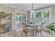Bright breakfast nook featuring tile flooring, a glass table and sliding glass door to the deck at 2721 Dahlgreen Rd, Raleigh, NC 27615