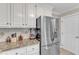 Kitchen featuring white cabinets, granite countertops, and stainless steel refrigerator at 2721 Dahlgreen Rd, Raleigh, NC 27615