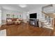 Spacious living room with hardwood floors, leather sofa, and ample natural light at 2721 Dahlgreen Rd, Raleigh, NC 27615