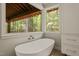 A luxurious soaking tub near a window provides natural light and scenic views at 2721 Silver Stirrup Ln, Apex, NC 27502