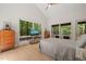 Bright bedroom with large windows offering tranquil forest views, vaulted ceilings, and modern furnishings at 2721 Silver Stirrup Ln, Apex, NC 27502