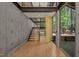 Modern entryway with concrete walls, wooden stairs, and an open door showcasing the natural landscape at 2721 Silver Stirrup Ln, Apex, NC 27502