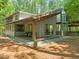 View of the house showing the covered porch with outside seating, stone facade, and wooded lot at 2721 Silver Stirrup Ln, Apex, NC 27502