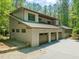 Side view of the home featuring a three car garage and manicured landscaping at 2721 Silver Stirrup Ln, Apex, NC 27502