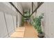 An elegant hallway with exposed concrete wall and wood floors flows toward stairway at 2721 Silver Stirrup Ln, Apex, NC 27502