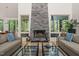 Living room features a stone fireplace, natural light, and floor-to-ceiling windows overlooking a forested setting at 2721 Silver Stirrup Ln, Apex, NC 27502