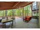 View of the open-air covered patio with a dining and seating area overlooking the wooded property at 2721 Silver Stirrup Ln, Apex, NC 27502