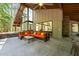 View of the outdoor living space with an orange sofa and a glass wall to the inside at 2721 Silver Stirrup Ln, Apex, NC 27502