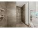 Walk-in shower with dark tile, rain shower head, and glass door at 2721 Silver Stirrup Ln, Apex, NC 27502