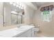 Well-lit bathroom features a vanity with mirror, tub with shower, and patterned window treatment at 3123 Amherst Ave, Burlington, NC 27215