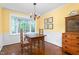 Inviting dining room features wood floors, large windows, a vintage table and chairs, and elegant lighting fixture at 3123 Amherst Ave, Burlington, NC 27215