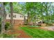 Beautiful two-story home exterior with a brick patio and a well-manicured lawn, surrounded by lush trees at 3123 Amherst Ave, Burlington, NC 27215