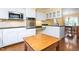 Bright kitchen with white cabinets, stainless steel microwave and oven, and black countertops overlooking the dining area at 3123 Amherst Ave, Burlington, NC 27215