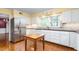 Charming kitchen with white cabinets, stainless steel refrigerator, wood island, and a view to the backyard at 3123 Amherst Ave, Burlington, NC 27215