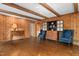 Living area showcasing wood paneled walls, a cabinet, hardwood floors, and comfortable blue armchairs at 3123 Amherst Ave, Burlington, NC 27215