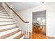 Staircase leading to the upper level, featuring wood steps, white railings, and an open view to the dining area at 3123 Amherst Ave, Burlington, NC 27215