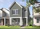 Charming two-story home featuring vertical siding, white trim, inviting front porch with rocking chairs and manicured lawn at 340 Cottage Hill Way, Raleigh, NC 27604