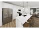 Modern kitchen featuring stainless steel appliances, a spacious island with bar seating, and bright white cabinetry at 346 Cottage Hill Way, Raleigh, NC 27604