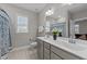 Bright bathroom with double sinks, tile flooring, a large mirror, and a blue patterned shower curtain, stylish and functional at 348 Golf Vista Trl, Holly Springs, NC 27540