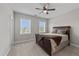 Comfortable bedroom with soft carpet, two windows, a ceiling fan, and a neatly made bed with throw blankets at 348 Golf Vista Trl, Holly Springs, NC 27540