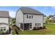 Rear exterior view of a gray two-story home with a screened porch, a well-maintained lawn, and black fencing at 348 Golf Vista Trl, Holly Springs, NC 27540