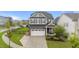 Beautifully landscaped home with a two-car garage, stone accents, and a welcoming front porch at 348 Golf Vista Trl, Holly Springs, NC 27540