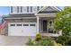 Charming home exterior with a two-car garage, stone accents, and a cozy front porch seating area at 348 Golf Vista Trl, Holly Springs, NC 27540