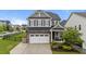 Charming two-story home featuring a gray exterior, a two-car garage, and manicured landscaping, with an American flag at 348 Golf Vista Trl, Holly Springs, NC 27540