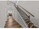Elegant foyer with wood flooring, a staircase with dark railings, and a view of the dining area at 348 Golf Vista Trl, Holly Springs, NC 27540